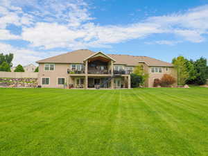 Back of house featuring stairs, stucco siding, a patio, a lawn, and roof with shingles