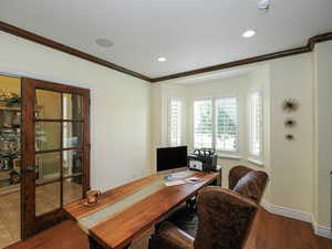 Office space with dark wood-style flooring, ornamental molding, and recessed lighting