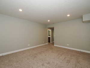 Carpeted empty room featuring a textured ceiling and recessed lighting