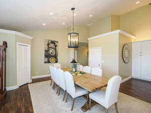 Dining area featuring dark wood-style floors, high vaulted ceiling, a chandelier, and recessed lighting