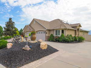 View of front of property with driveway, stucco siding, an attached garage, and roof with shingles