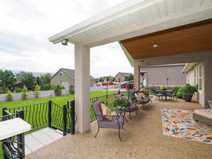 Fenced backyard with a patio area, outdoor dining space, and a residential view