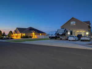 View of front of home with driveway, stucco siding, and a front lawn