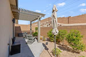 Fenced backyard featuring a patio and a pergola