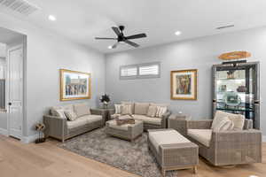 Living room featuring light wood finished floors, a ceiling fan, and recessed lighting