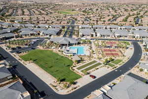 Aerial view of property and surrounding area featuring nearby suburban area and a pool