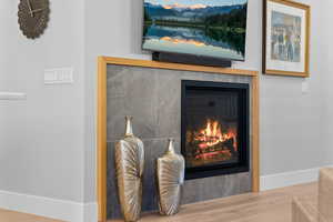 Detailed view of wood finished floors and a tile fireplace