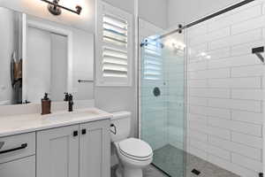 Bathroom with tiled shower and vanity
