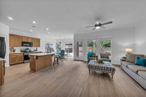 Living room with recessed lighting, light wood-style flooring, and ceiling fan