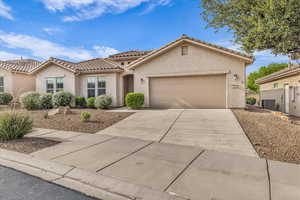 Mediterranean / spanish home with stucco siding, concrete driveway, a tiled roof, and a garage