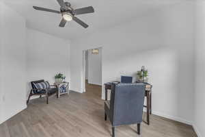 Office area with light wood-type flooring and ceiling fan