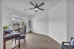 Living area with light wood finished floors, an office area, and a ceiling fan
