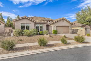 Mediterranean / spanish-style house with stucco siding, a tile roof, concrete driveway, and an attached garage