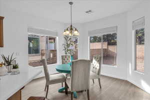 Dining area with light wood finished floors and a chandelier