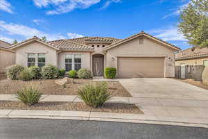 Mediterranean / spanish home featuring stucco siding, a tiled roof, driveway, and a garage