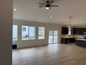 Kitchen with light countertops, light wood-style flooring, recessed lighting, pendant lighting, and tasteful backsplash