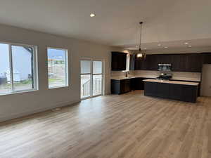 Kitchen with decorative backsplash, light countertops, light wood finished floors, recessed lighting, and a center island