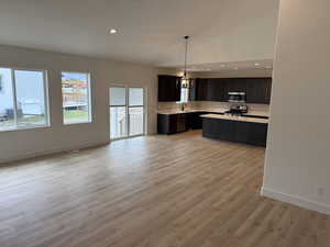 Kitchen with light countertops, decorative backsplash, recessed lighting, decorative light fixtures, and lofted ceiling