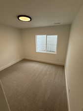 Spare room with light carpet and baseboards