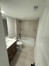 Bathroom with shower / bathtub combination, vanity, and a textured ceiling