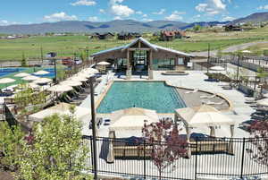 Community pool featuring a patio area, a mountain view, and a view of rural / pastoral area