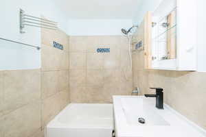 Bathroom with shower / bath combination and vanity