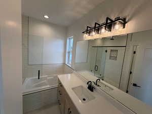 Bathroom featuring vanity, a shower stall, a garden tub, recessed lighting, and light tile patterned flooring