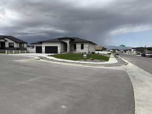 View of front of house featuring a residential view, stone siding, driveway, and a garage