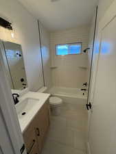 Bathroom featuring bathtub / shower combination, vanity, and light tile patterned floors