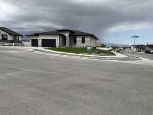 View of front of house with a residential view, an attached garage, driveway, and stone siding