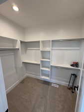 Walk in closet featuring dark carpet