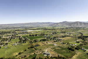 Aerial view of sparsely populated area featuring mountains and large plots for crops