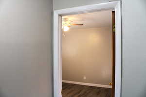 Hall with dark wood-style floors and baseboards