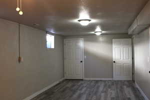Below grade area featuring wood finished floors and a textured ceiling