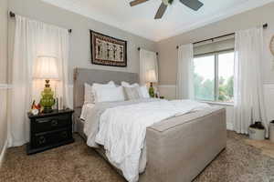 Primary Bedroom featuring carpet floors, crown molding, and a ceiling fan