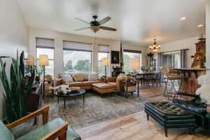 Living area with light wood-style floors, a ceiling fan, recessed lighting, and a chandelier