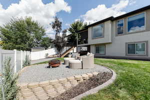 Fenced backyard featuring a fire pit, a patio, and stairway