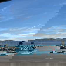 Water view featuring a marina, mountains, and a dock