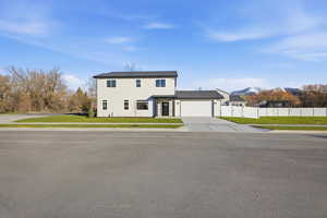 View of front of home featuring concrete driveway and an attached garage