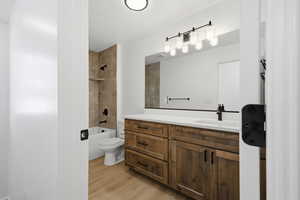 Bathroom with vanity, bathtub / shower combination, and light wood-type flooring