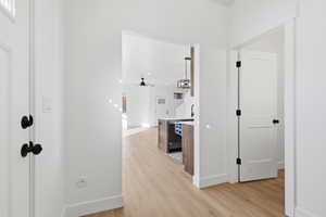 Hallway featuring light wood-type flooring and baseboards