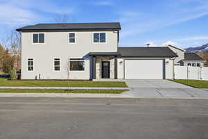 View of front facade featuring concrete driveway, a garage, and stone siding