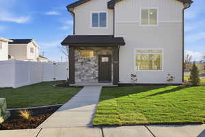 View of front of house with stone siding and board and batten siding