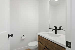 Half bath featuring vanity and toilet