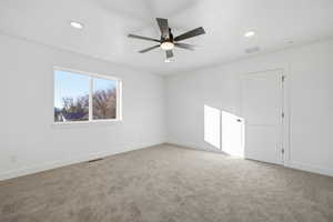 Spare room featuring light colored carpet, a ceiling fan, and recessed lighting