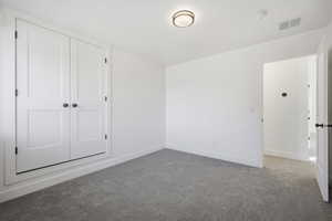 Unfurnished bedroom featuring carpet and a closet