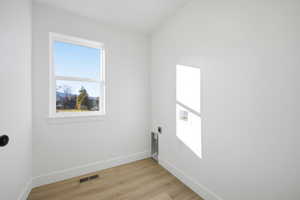 Laundry area featuring light wood-style flooring, washer hookup, and electric dryer hookup