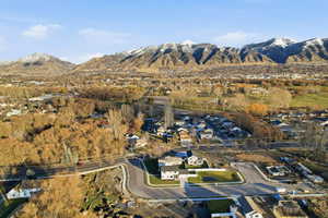Aerial view of property and surrounding area with a mountain backdrop