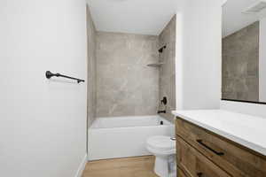 Bathroom featuring bathing tub / shower combination, vanity, and light wood-style flooring