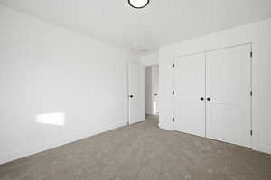 Unfurnished bedroom featuring carpet and a closet